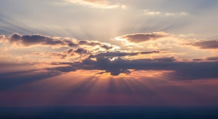 Breathtaking sky with sunbeams shining through dramatic clouds at sunrise or sunset, casting a warm, ethereal glow and creating a serene natural backdrop.