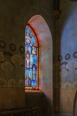Beautiful Stained Glass Window Illuminates Gothic Stone Archway in Historic Religious Interior. Colorful religious artwork, Montserrat, sacred light filtering