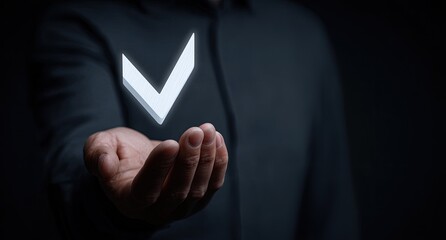 A person's hand, dark-clad, holds a glowing white checkmark in mid-air