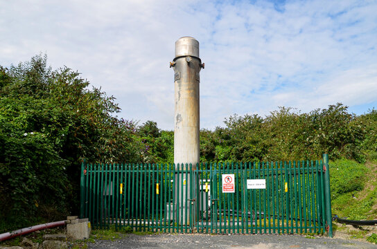 A flare stack at a landfill burns off methane gas, preventing it from being released into the atmosphere, an important step in environmental protection.