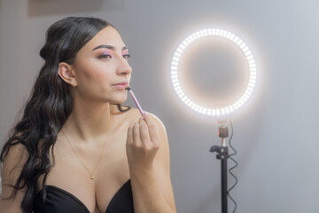 Woman applying makeup with a ring light