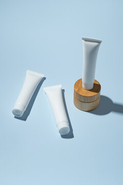 White cosmetic cream tubes on a blue presentation background