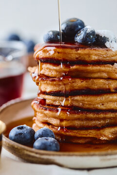 Stack of pancakes with blueberries and syrup drizzle