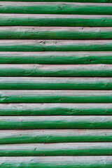 background of old weathered and cracked boards with peeling paint of green color