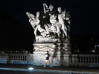 Young girl in motion on Ponte Vittorio Emanuele II at night, Rome