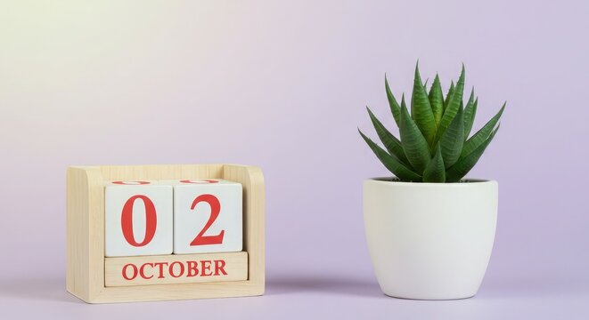 Wooden calendar blocks displaying October 2nd, next to a small potted succulent plant on a purple background.
