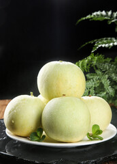 Freshly Picked Green Melons with Water Droplets on White Plate with Mint and Fern Background