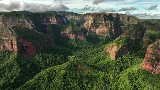 Aerial view of the vibrant green forest contrasting with the red rock formations of Amboro National Park, Samaipata, Bolivia.