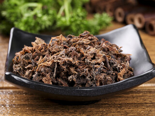 Dried Prunes in Black Ceramic Bowl on Wooden Table - Healthy Natural Snack Food
