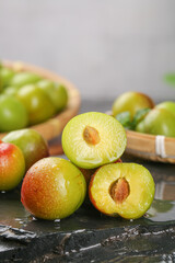 Fresh Cut Plums Showing Pit and Juicy Flesh on Rustic Wood Surface
