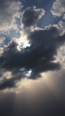 Obraz premium View of dramatic sky with dark and light clouds with sunlight shining through the cloud formations above