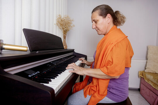 Middle-aged woman enjoying piano music at home