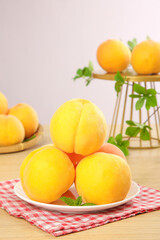 Fresh Sweet Yellow Peaches on White Plate with Mint Leaves Kitchen Table Still Life