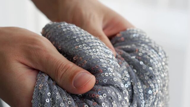 Sequins on a silver women's dress.
Glamorous and shiny women's clothing with sequins that shimmer beautifully in the light close-up.
Sequins sewn onto tulle