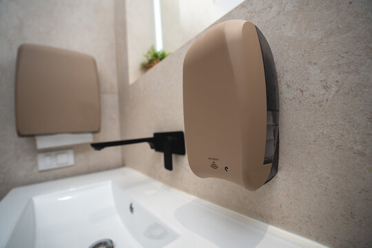 Sandy texture touchless soap dispenser in a luxury bathroom
