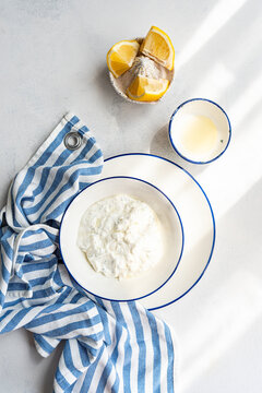 Tzatziki sauce with lemon on a white plate
