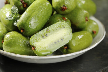 Fresh Green Kiwi Berries in Bowl - Small Soft Skin Exotic Fruit with Deep Green Flesh and Black Seeds
