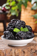 Dried Prunes with Mint in Bowl on Wooden Base - Healthy Snack Food Photography