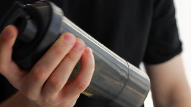 An athlete uses a shaker to mix sports nutrition, protein or creatine after exercise.
Black shaker for protein.
Using sports nutrition and supplements for muscle growth and strength gain