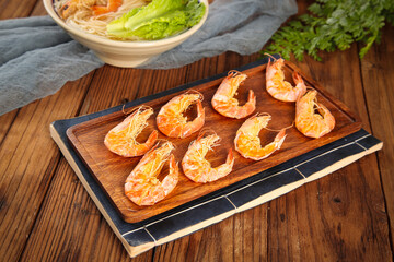 Cooked Shrimp on Wooden Board with Pasta Bowl Background - Seafood Kitchen Preparation