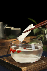 Chinese Iron Yam Herbal Medicine Slices Being Added to Traditional Therapeutic Soup with Chopsticks