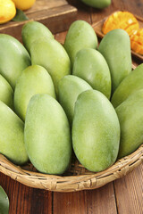 Fresh Green Mangoes in Wicker Basket at Tropical Fruit Market Display