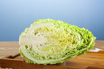 Fototapeta premium Fresh Cabbage Half Cut on Wooden Cutting Board - Healthy Vegetable Ingredient for Cooking