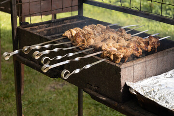 Juicy slices of meat prepare on the fire. Tasty shish kebab on skewers. Grilled marinated barbecue meat - shashlik on pork