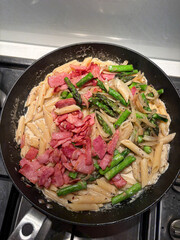 Creamy penne pasta with bacon and asparagus.