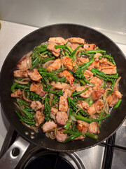 Chicken and broccolini stir fry in the pan.
