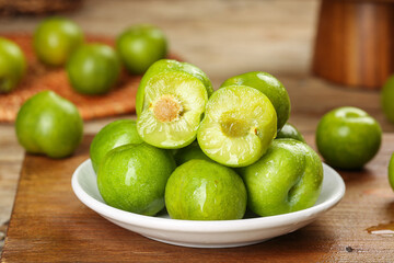 Fresh Green Plums in White Bowl on Rustic Wood Table - Healthy Organic Stone Fruit
