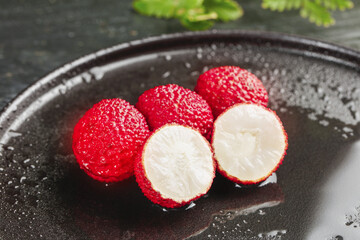 Fresh Lychee Fruits from Guangxi China on Dark Plate Showing White Flesh and Red Skin