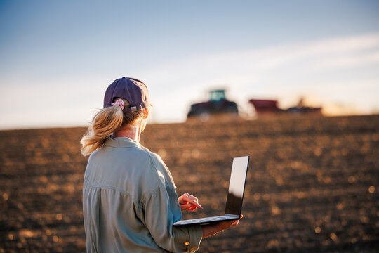 Farmer woman using laptop for smart farming analyzing data in field