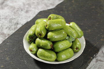 Fresh Green Kiwi Berries in Bowl - Healthy Exotic Superfruit Snack on Slate Background