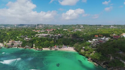 Aerial pullback view from famous Padang Padang white sandy beach in Uluwatu