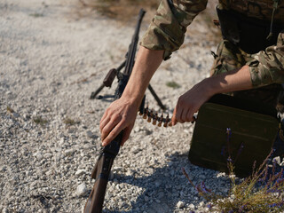 Fototapeta premium Close-up of Ukrainian Soldier loading machine gun`