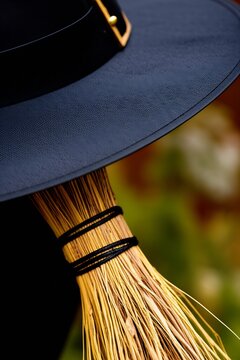 A witch wearing a classic pointy hat, holding a weathered broomstick, ready for a magical flight under a mystical sky.