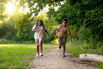 Two teens running in the park and looking contented