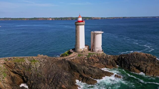 Iconic Petit Minou lighthouse standing tall on its rocky outcrop against vast blue sea highlighting its architectural details near the fort in Plouzan&eacute;, Brittany, France, drone push in and close up