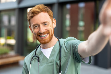 Man doctor smiling to camera while taking selfie
