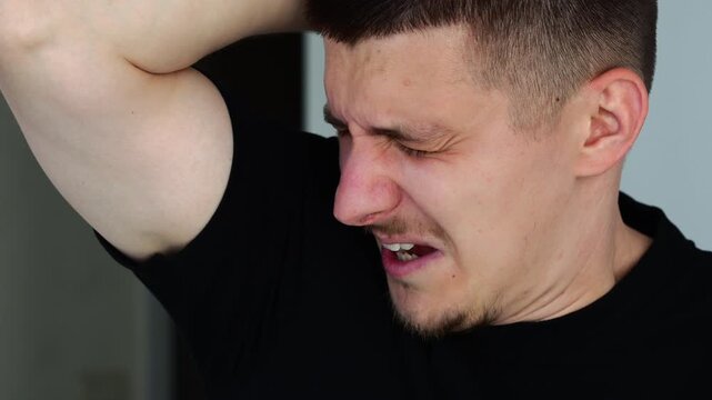 Man covers himself after smelling sweaty and smelly armpit.
Dirty and sweaty armpits.
Body sweat odor due to poor hygiene and grooming