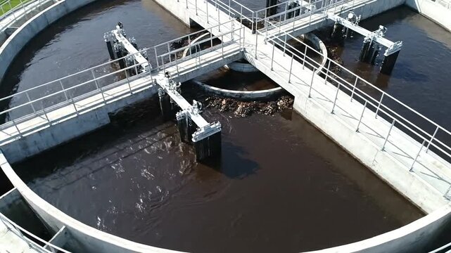 An aerial view of a circular clarifier tank at a wastewater treatment plant processing sewage.