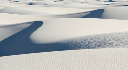 Expansive white sand dunes under a clear sky, a vast desert landscape