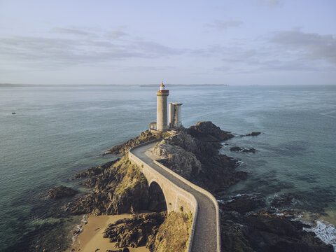 Aerial view of the Petit Minou lighthouse standing tall on Pointe du Minou, connected by a winding causeway amidst the contrasting blues of the sea, Plouzan&Atilde;&copy;, Finist&Atilde;&uml;re, France.