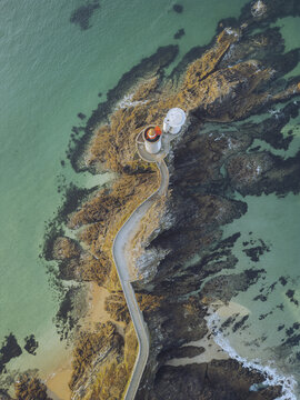Aerial view of the Pointe du Minou lighthouse standing proudly against the rugged coastline, where turquoise waters meet weathered rocks, Plouzan&Atilde;&copy;, Finist&Atilde;&uml;re, France.