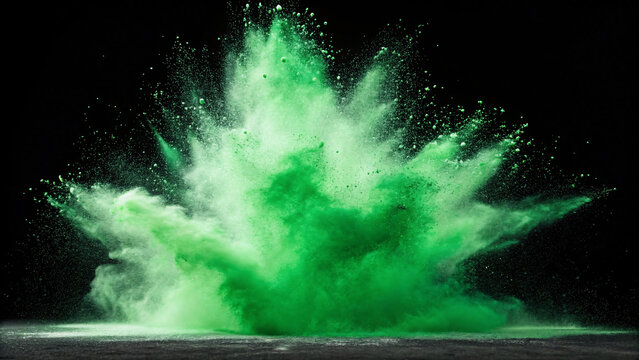 Intense green powder explosion captured mid-burst, billowing clouds of fine particles spreading dramatically against stark black background surface.