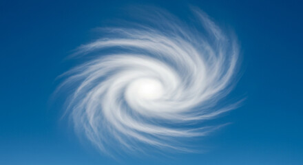 Powerful swirling clouds form a dramatic hurricane eye against a clear blue sky
