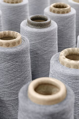Group of large spools of thread of gray color