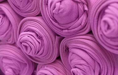 Knitted pink fabric rolled into rolls