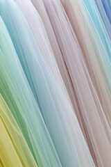 Vertical folds of translucent fabric in various pastel colors